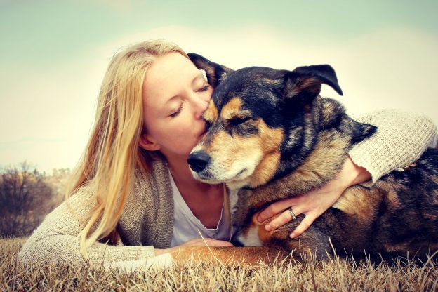 Rehoming a rescue dog - owner and dog cuddling outside