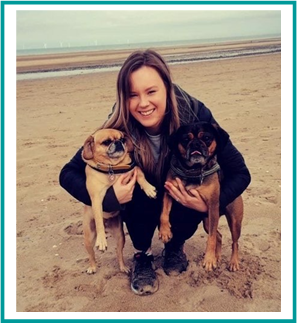Vetsure's Claims Assessor Kayleigh cuddles her dogs at the beach.