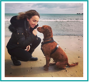 Vetsure's claims assessor Fiona gives her dog a treat at the beach!
